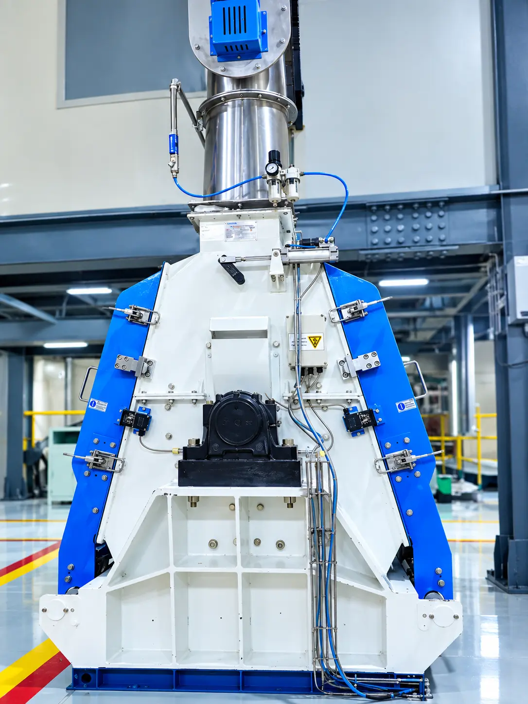 Large blue and white industrial processing machine on the production floor
