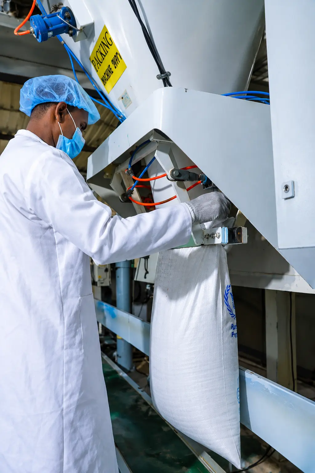 Quarit food-processing worker filling a product bag on the packing line